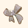 Light-luxury High-end Full-diamond Bow Brooch — actual supplier photograph on warm ivory